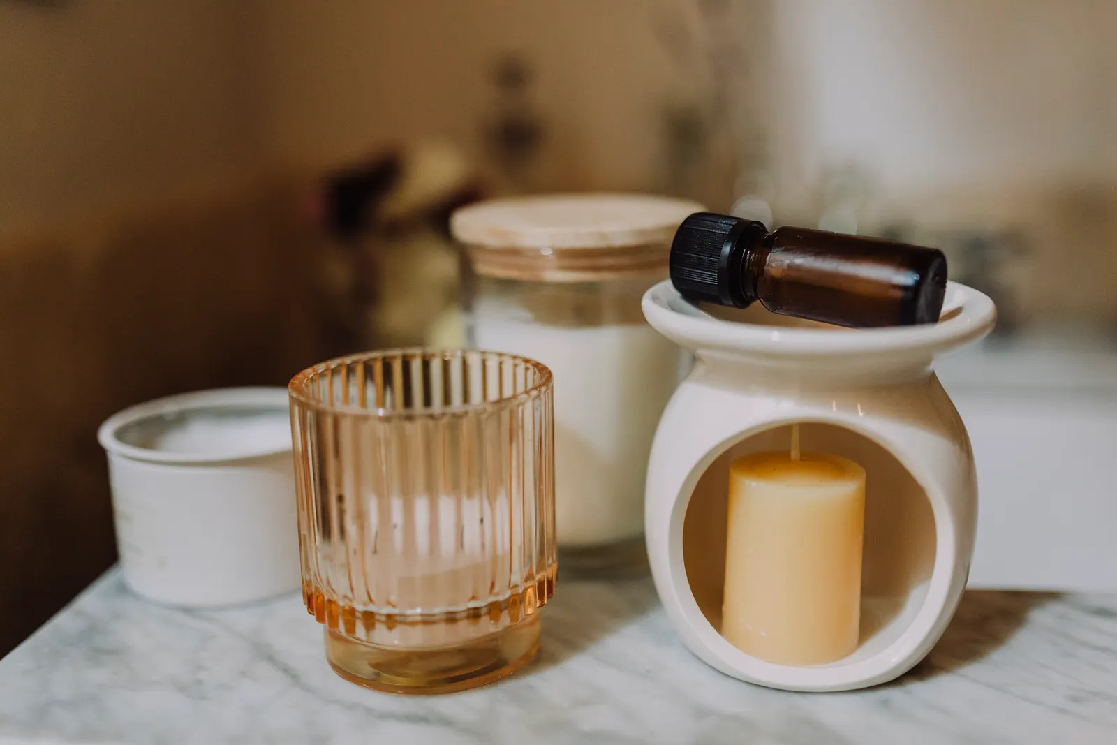 Serene aromatherapy arrangement with candles and essential oil on marble